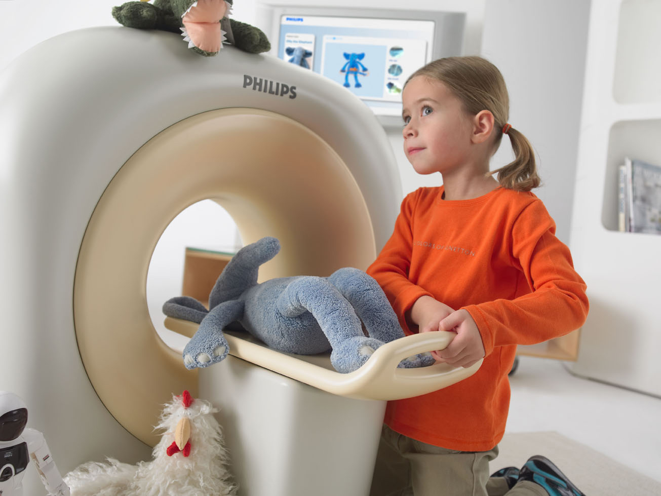 Kid putting teddy in scanner